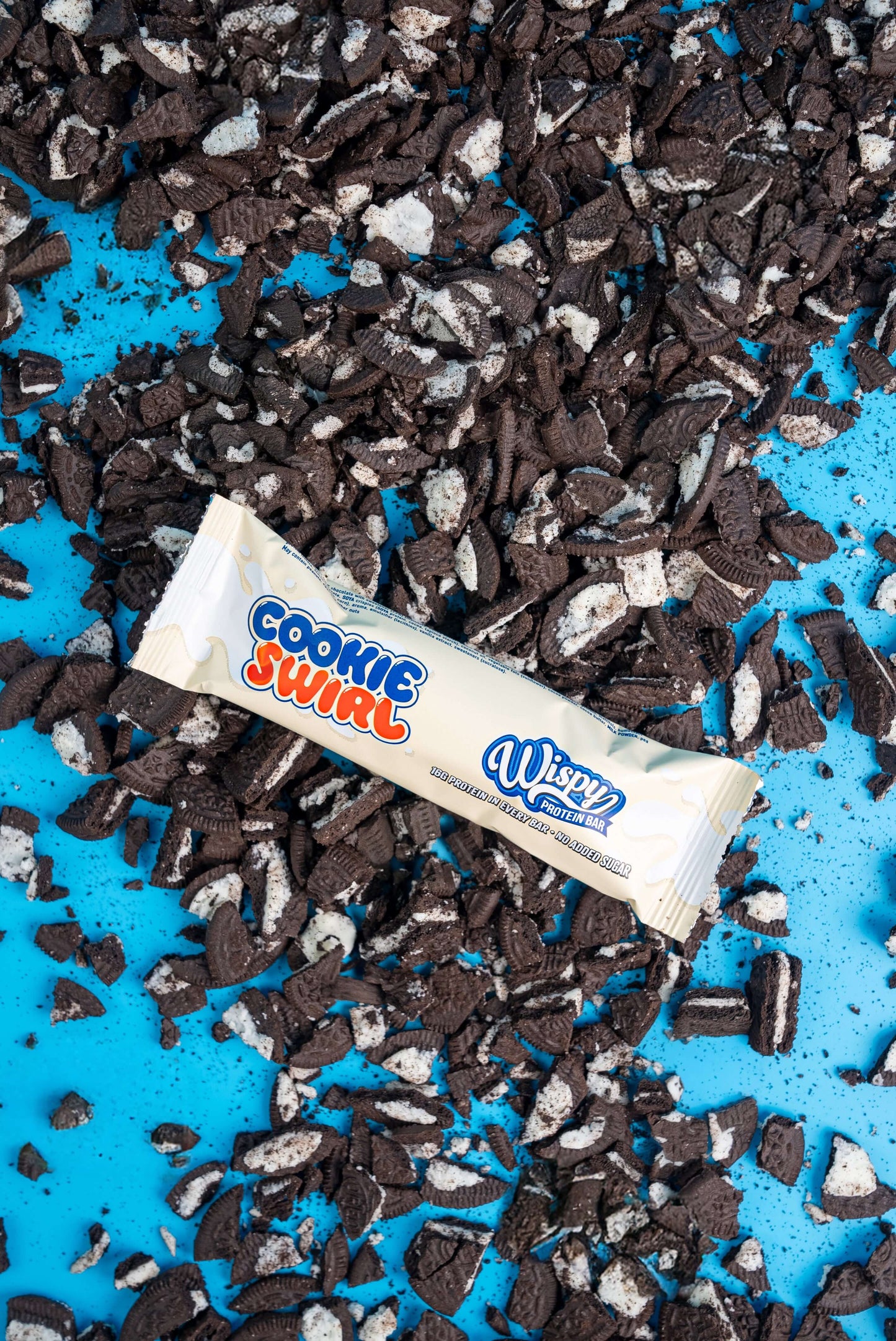 Wispy Eiwitreep Verpakking in de Smaak Cookie Swirl met Cookies op achtergrond